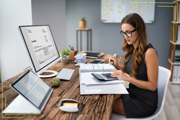 lady looking at computer and calculator